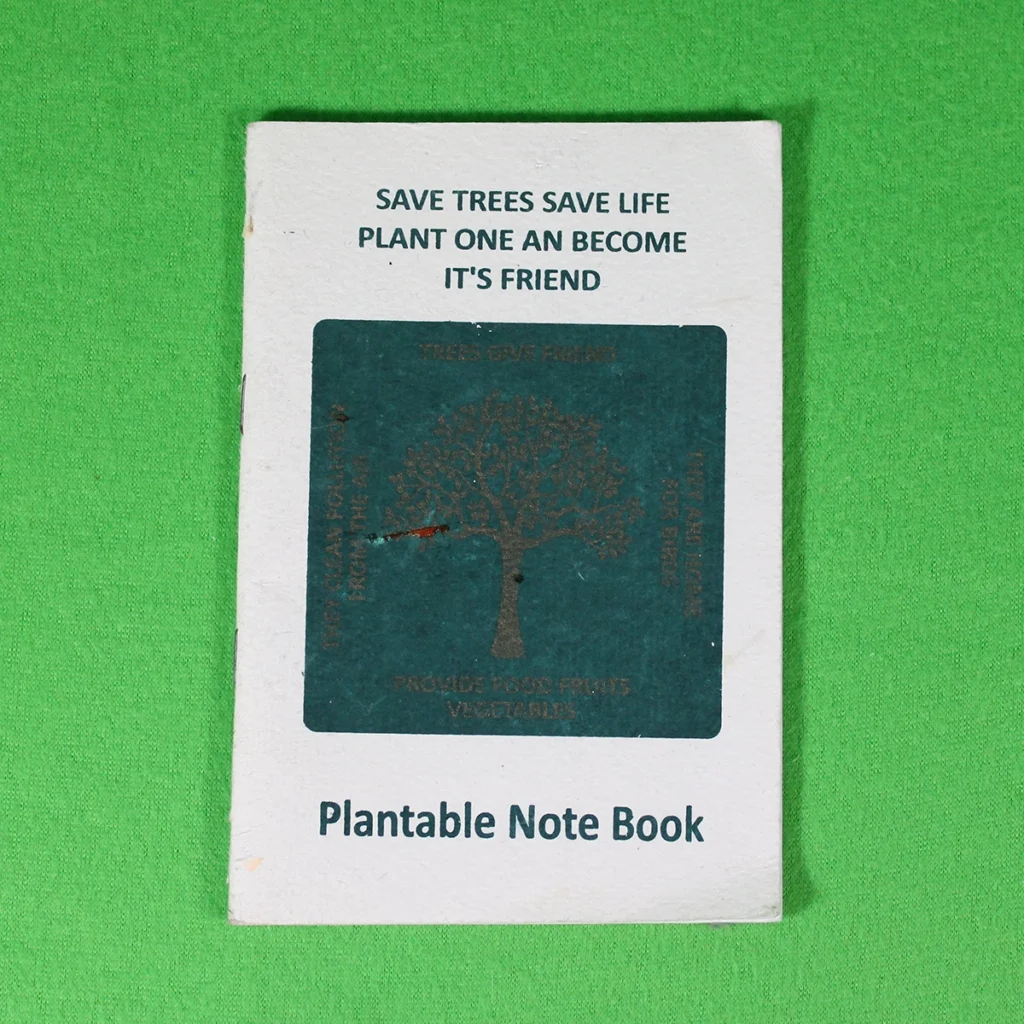 Small eco-friendly plantable notebook with a dark green patch and “Save Trees Save Life” slogan on the cover, 18 x 12 cm